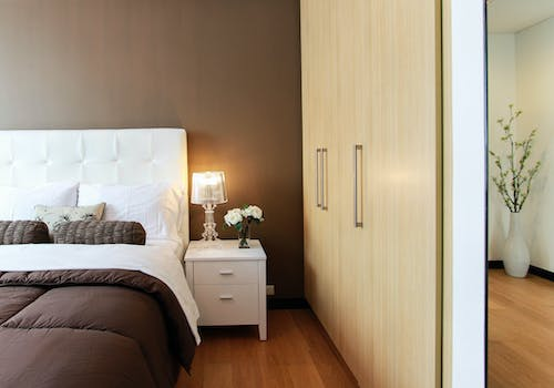 a bedroom with an accent wall and wooden flooring