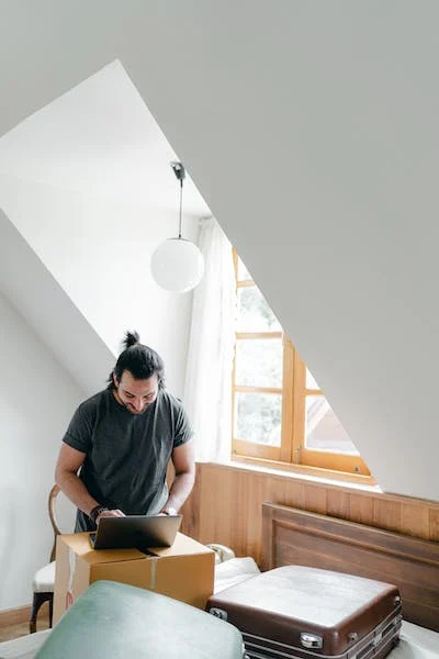 a man browsing the internet in an attic-style room