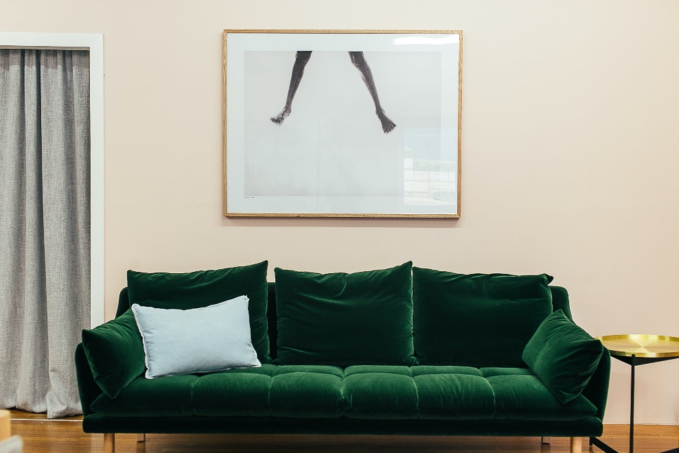 Green sofa with a pillow on it